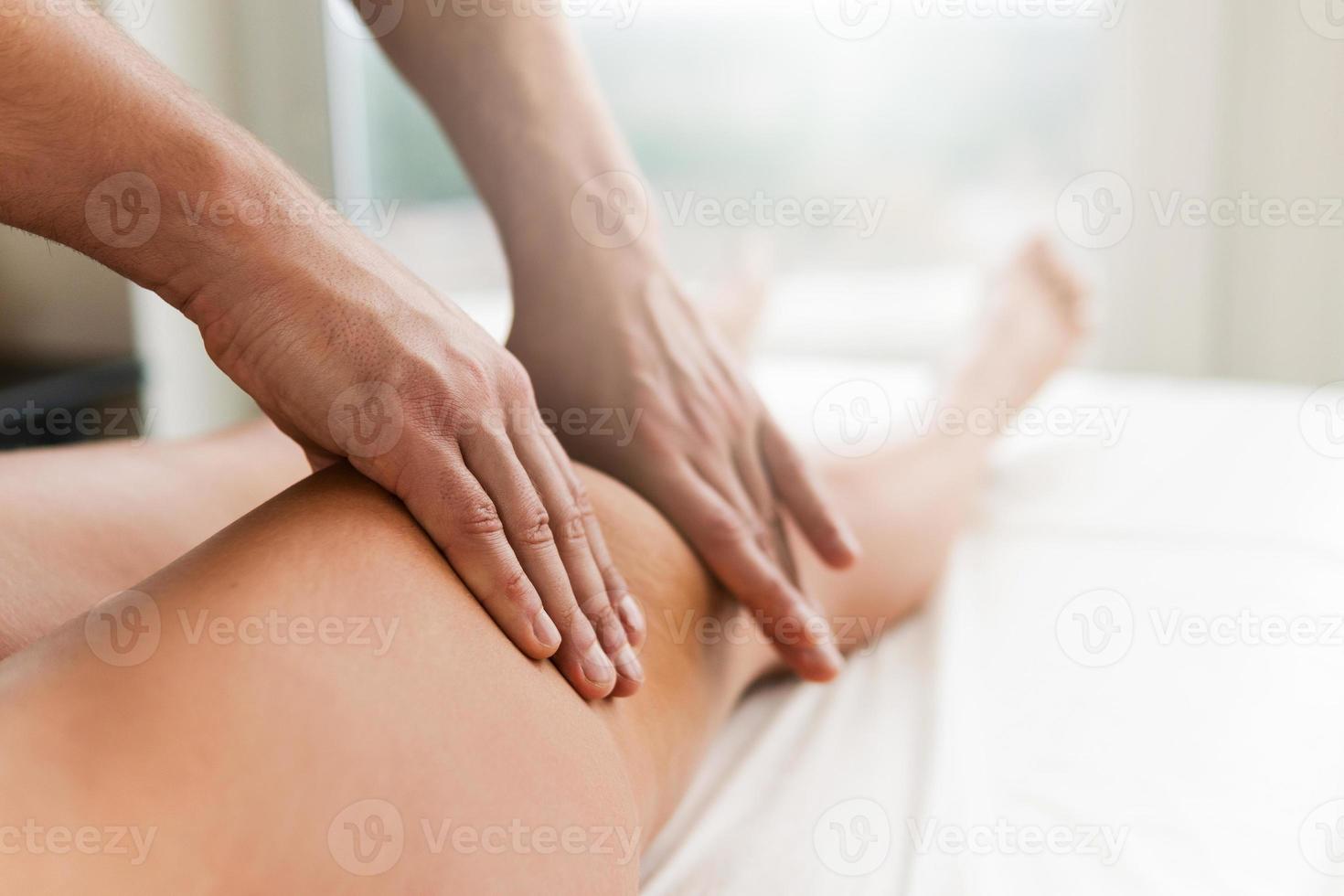 Manual therapist working with a client during leg massage photo