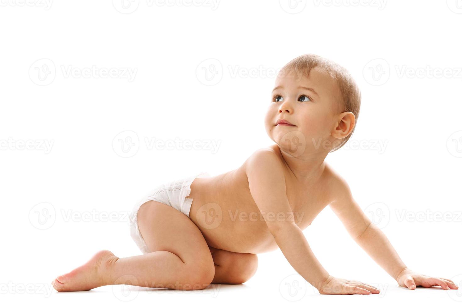 curioso niño sano en pañales arrastrándose y mirando. foto