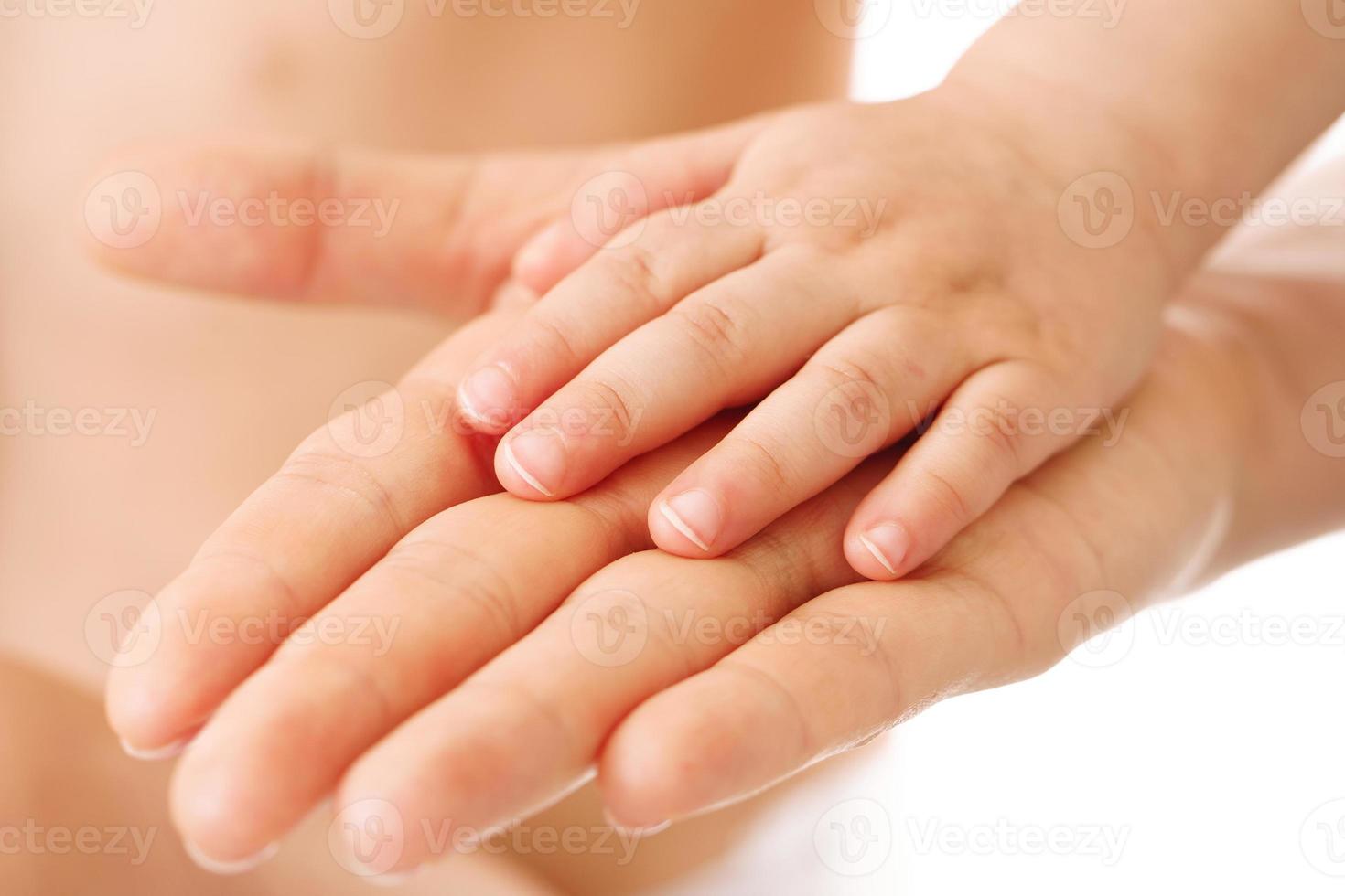 Little child placing hand on his mother palm. photo
