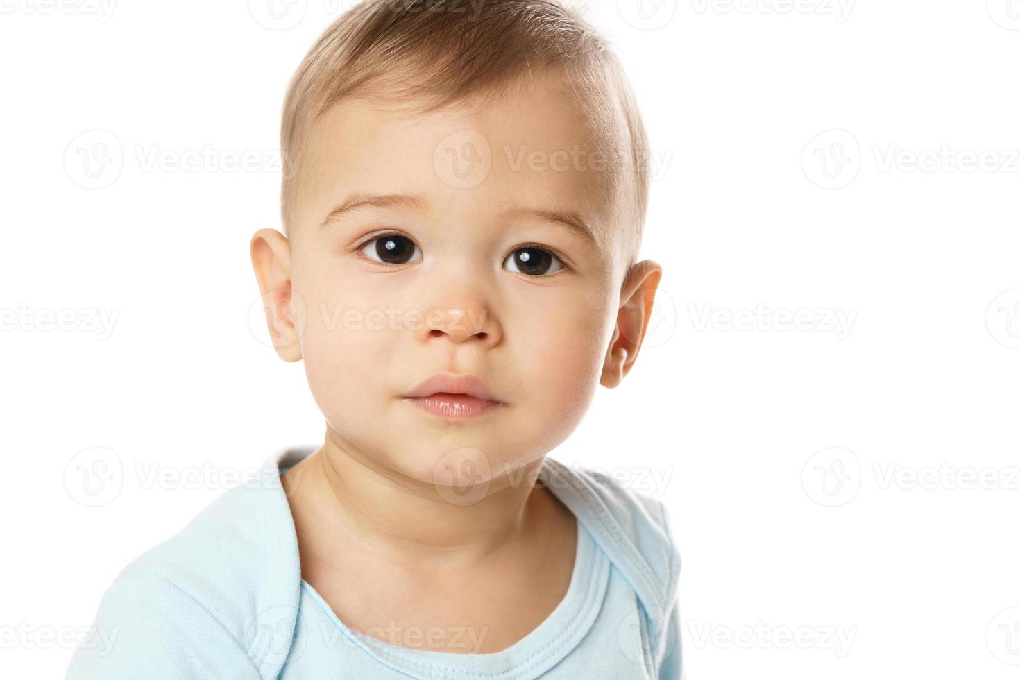 tiro closeuo de cara curiosa de niño pequeño en mameluco. foto