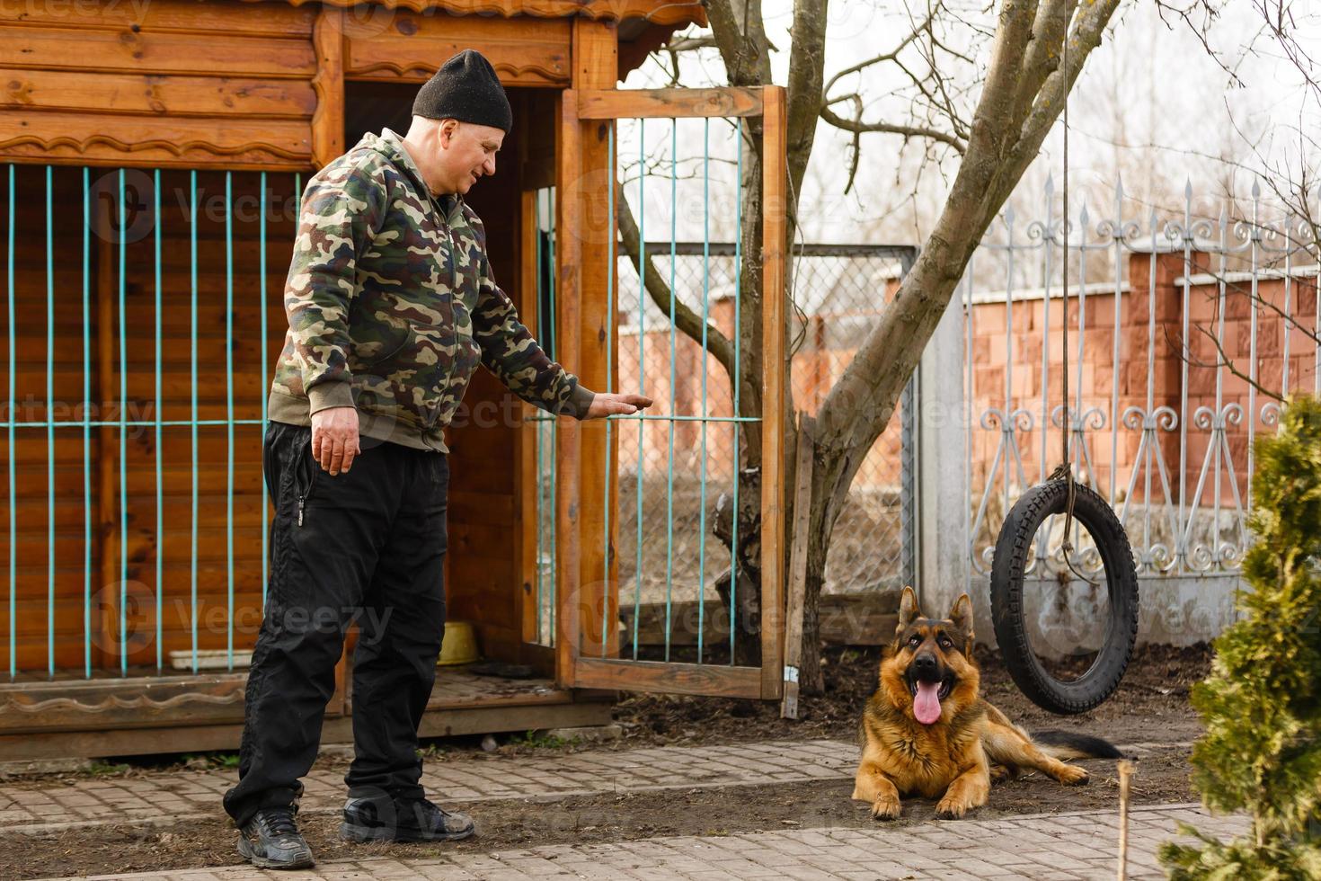 A man training his german shepherd dog outdoors photo