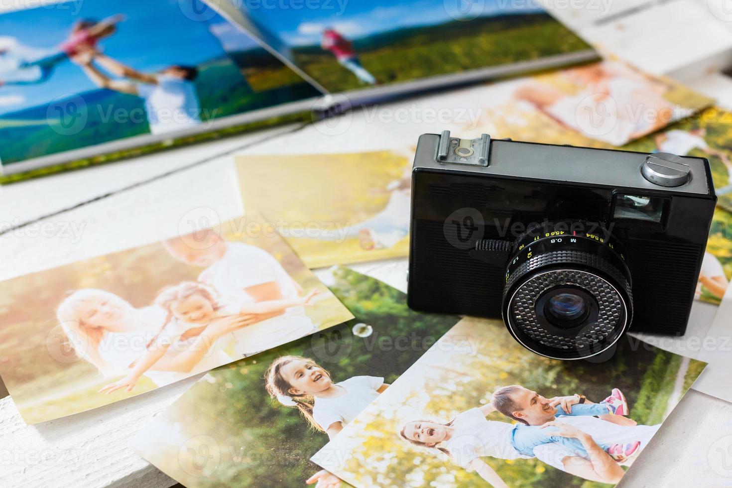 vintage camera and old photos on wooden background. nostalgic style picture