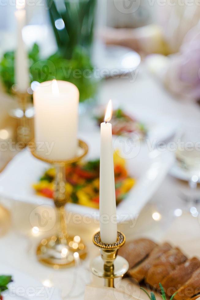 Close-up shot of a burning canlde on a festive table. photo