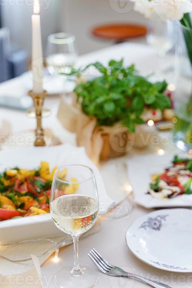 Festive table with food, wine, flowers and candles. photo