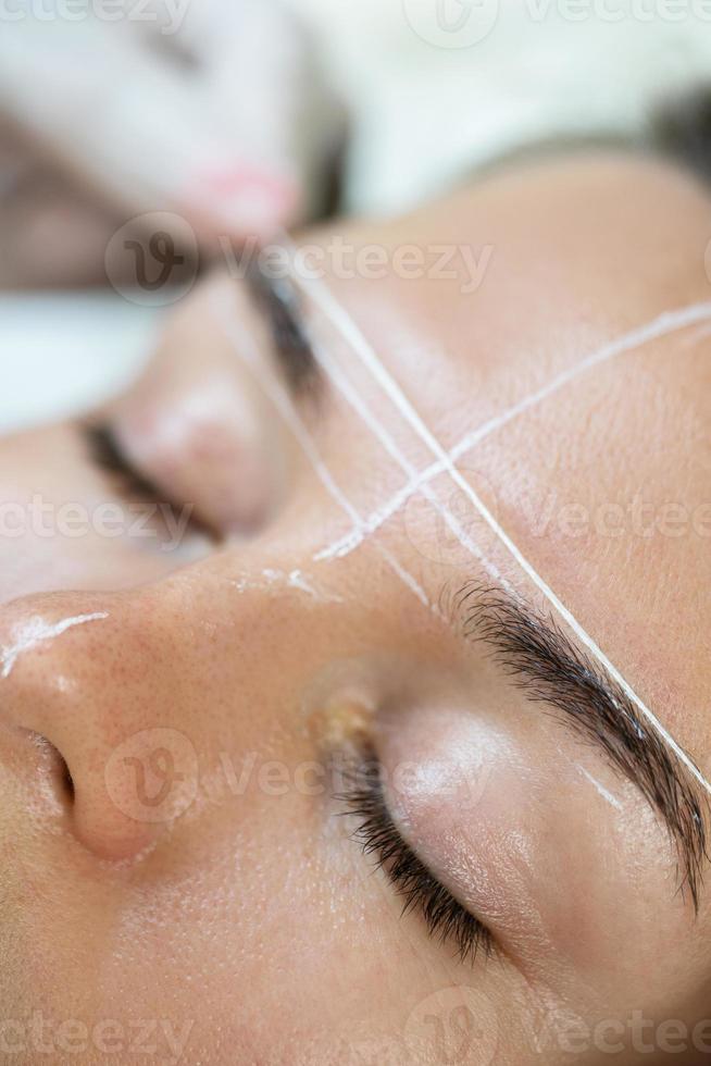 Woman during professional eyebrow mapping procedure photo