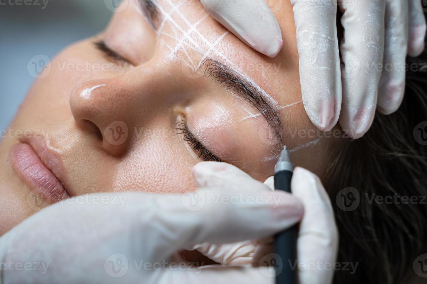 Woman during professional eyebrow mapping procedure photo