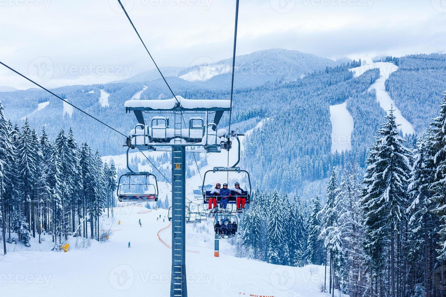 Skiers on chairlift at ski resort photo