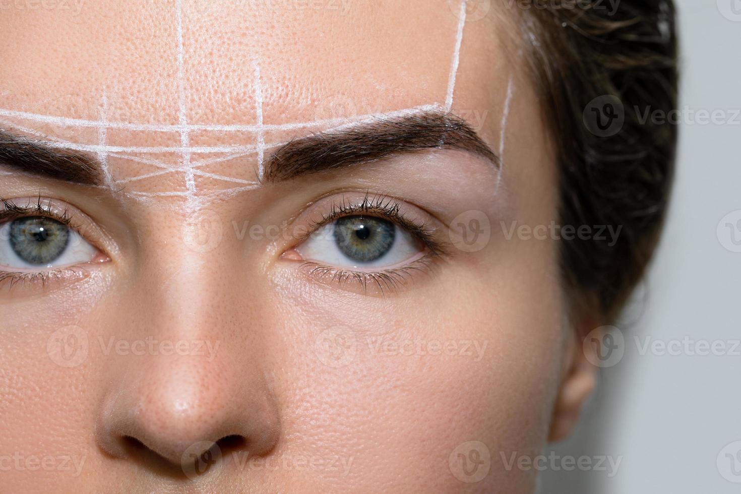 Woman during professional eyebrow mapping procedure photo