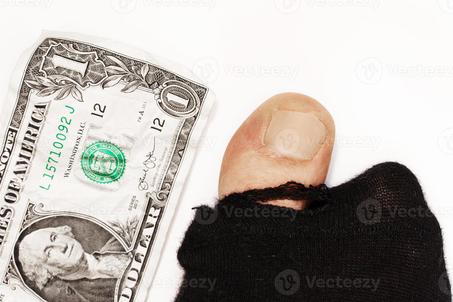 One dollar banknote and hoaly sock with sticking out toe. photo