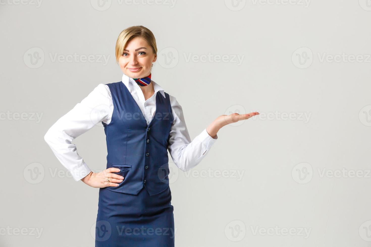 retrato de una encantadora azafata vestida con uniforme azul. aislado sobre fondo blanco foto