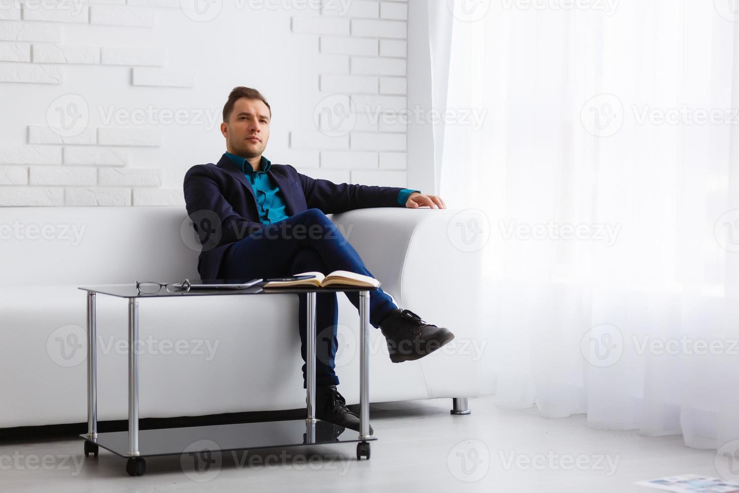 young businessman on a white sofa on white background photo