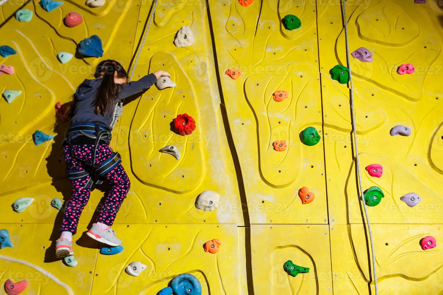 Little Girl Climbing Rock Wall photo