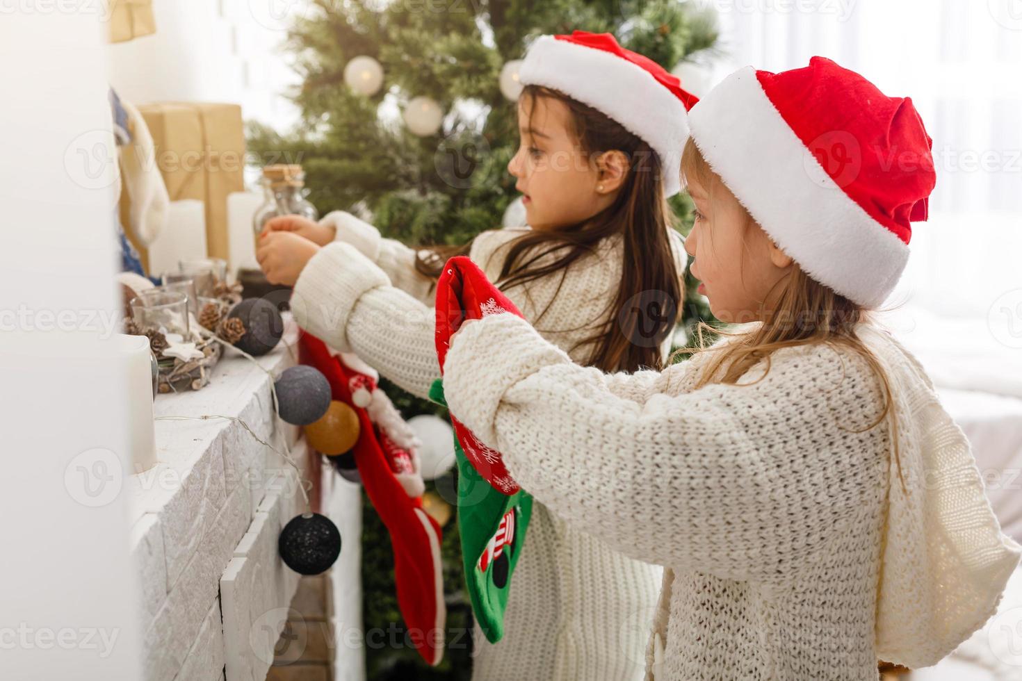 Kids little sisters hold gifts boxes interior background. What a great surprise. Small cute girls received holiday gifts. Best toys and christmas gifts. Children friends excited unpacking their gifts. photo