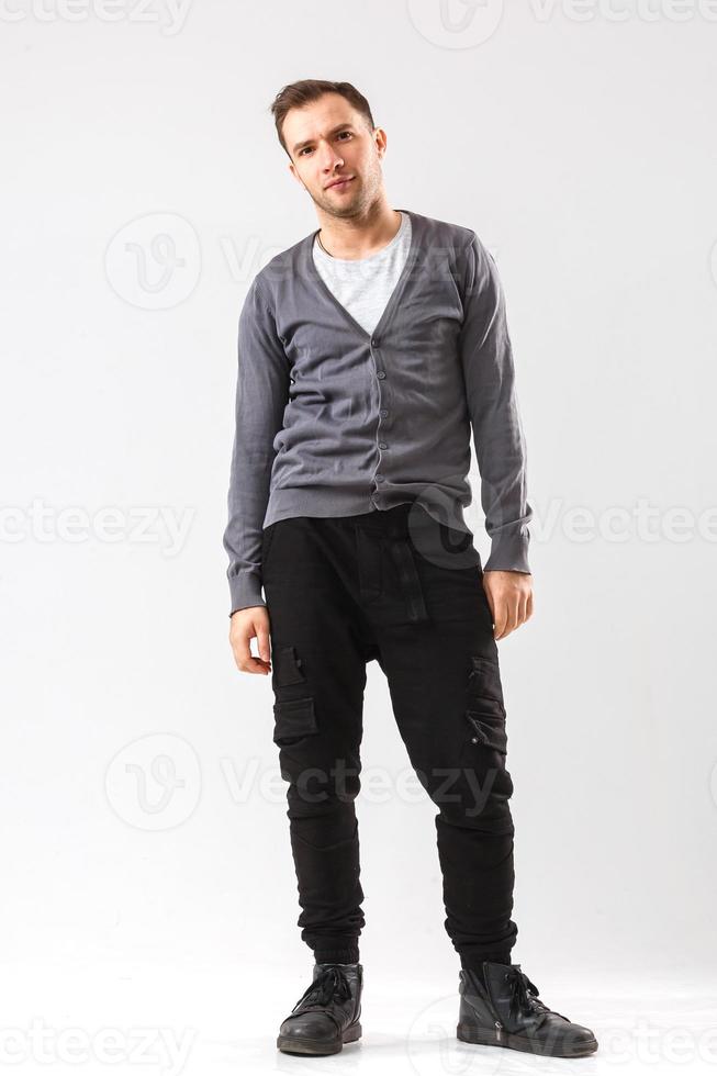 Casually handsome. Confident young handsome man keeping arms crossed and smiling while standing against white background photo