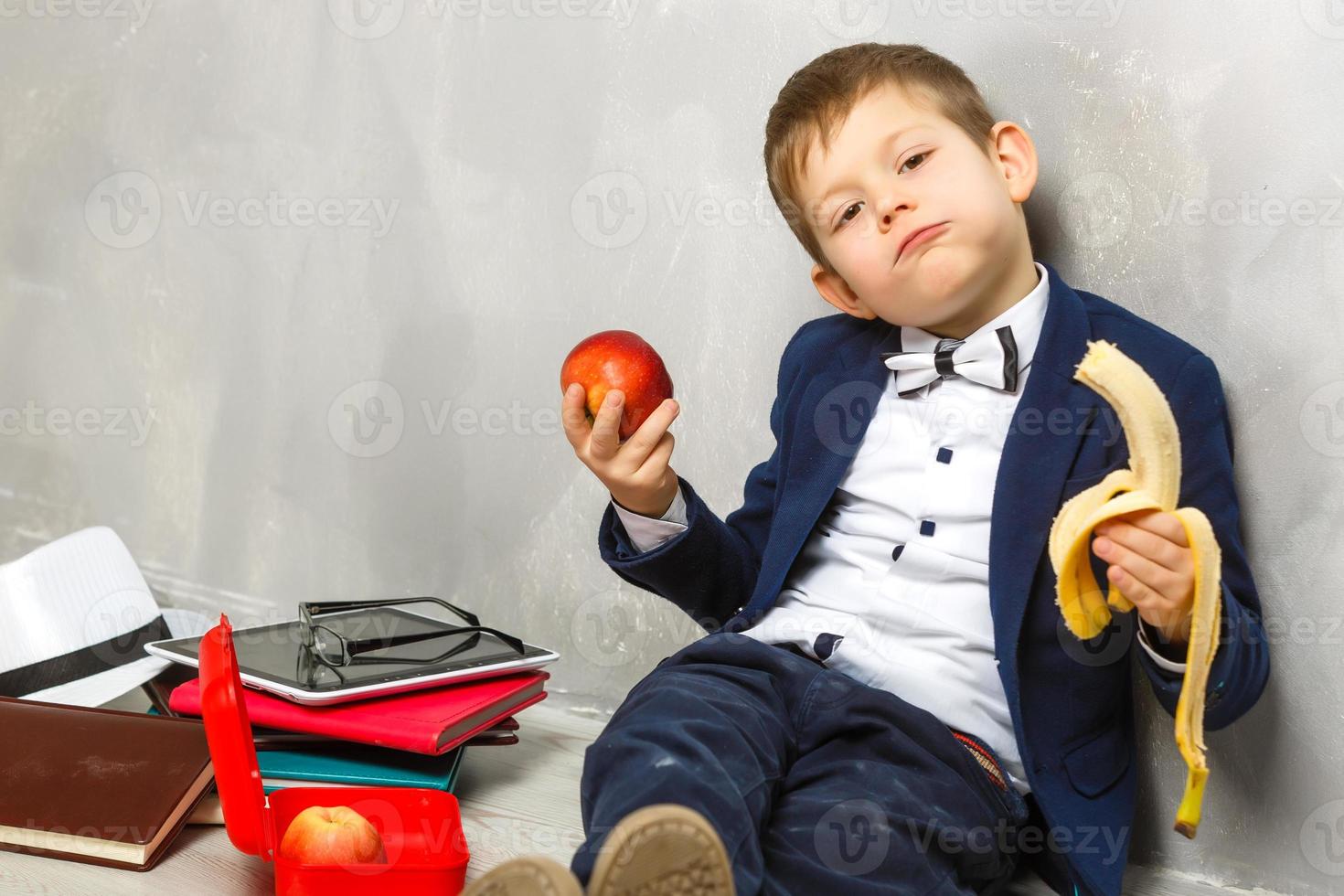 Schoolboy having a sandwich and an apple during his lunch break photo
