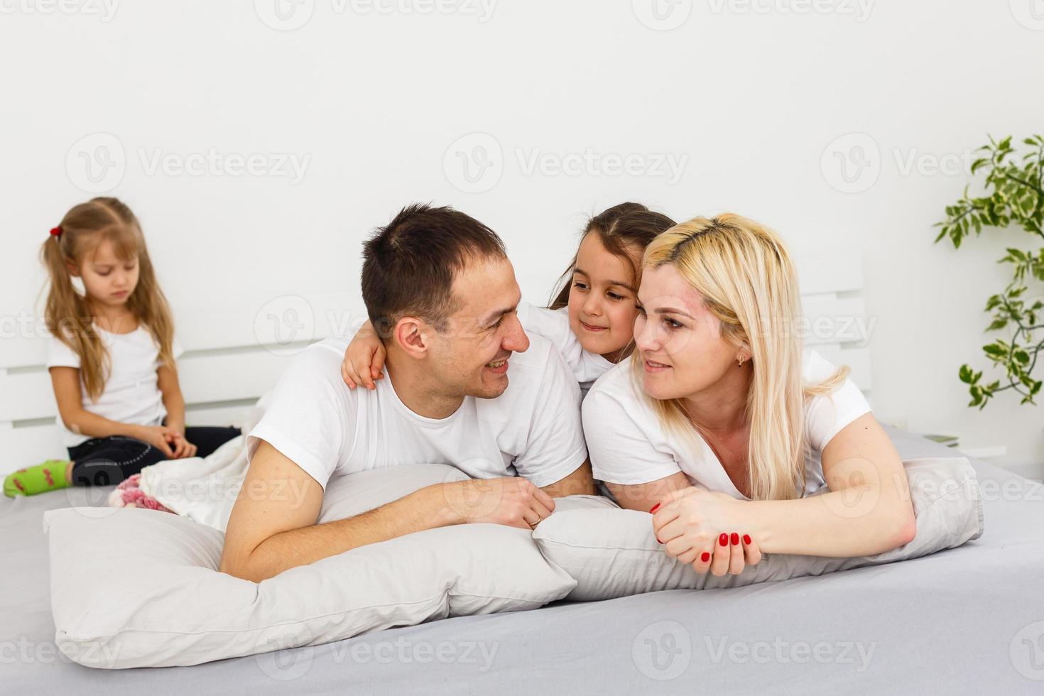 A young family with young children to bed in the bedroom photo