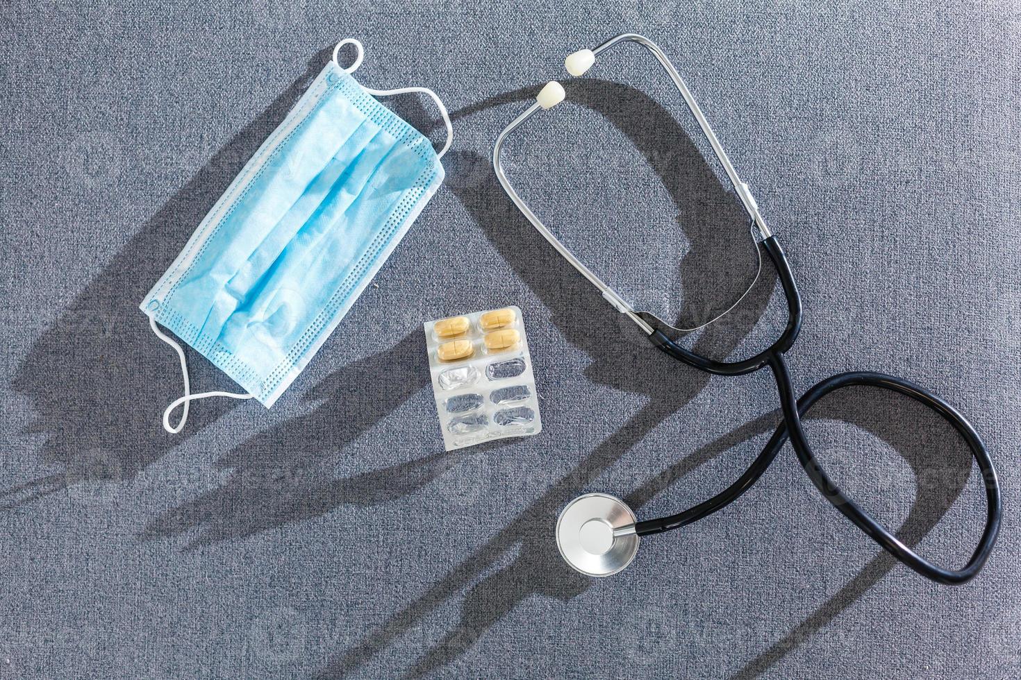 Pharmacy background on a white table. Tablets on a white background. Pills. Medicine and healthy. Close up of capsules. Stethoscope on a white wooden background. Copy space for a text photo