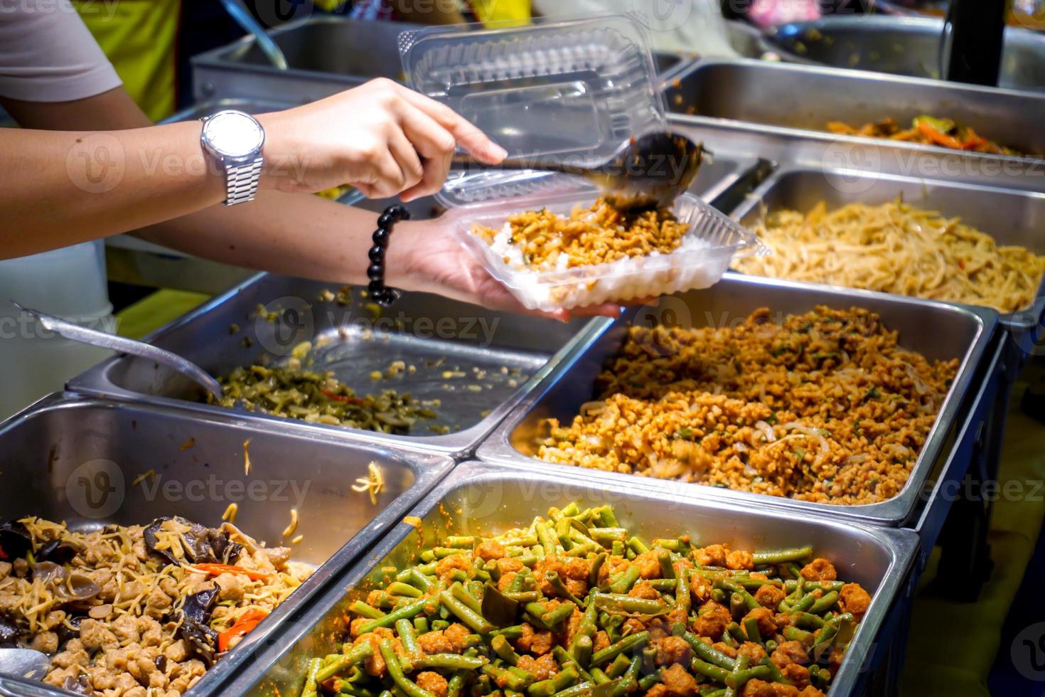 Closeup variety vegan Chinese food sell in food market for welcome of Chinese lunar new year 2020 with hand of trader selling food to customer. photo