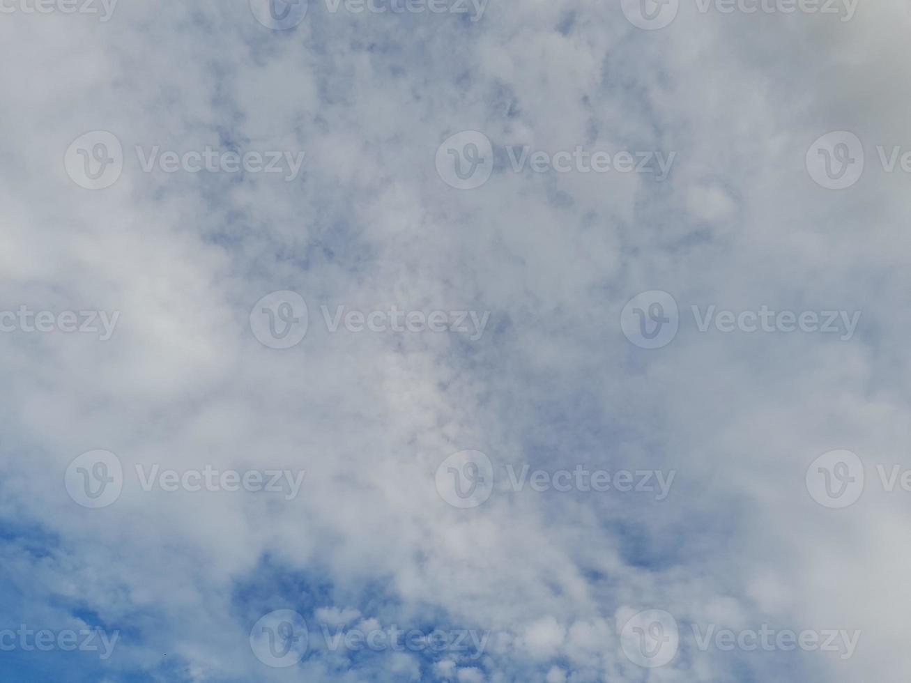 White clouds in the blue sky. Heaven and infinity. Beautiful bright blue background. Light cloudy, good weather. Curly clouds on a sunny day. photo