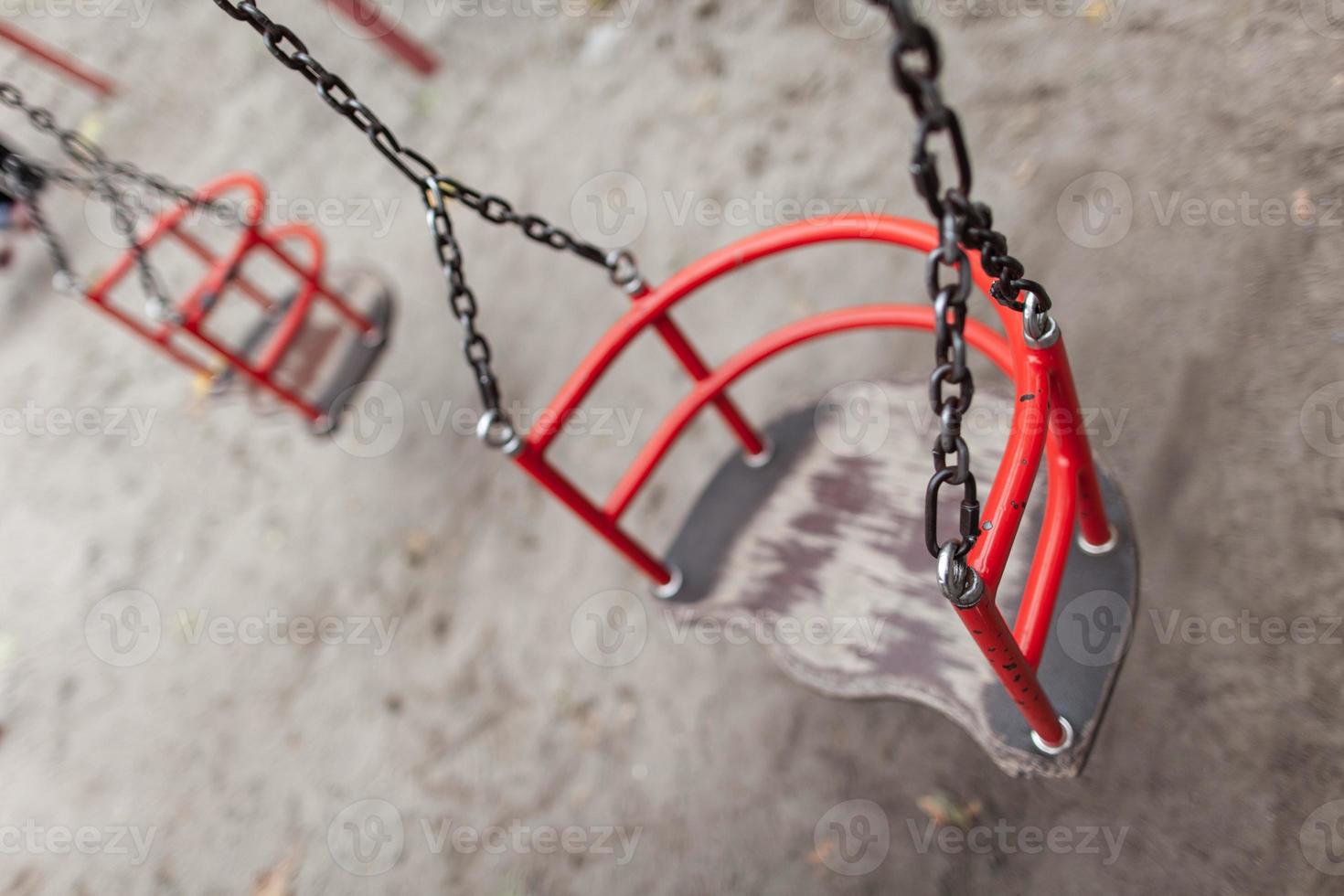 a lonely empty swing on a playground without people. photo