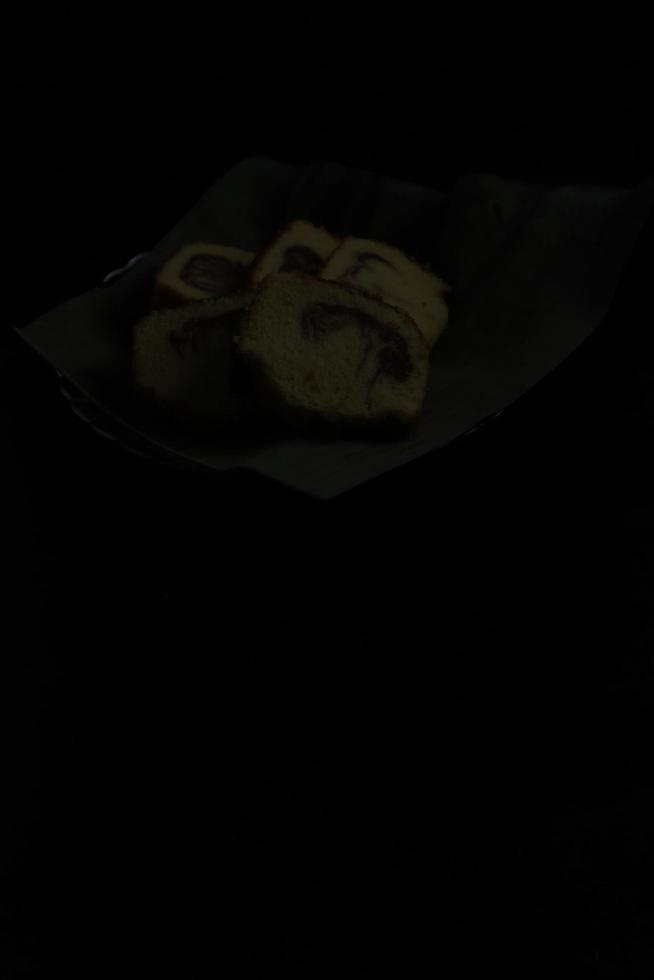 cake in a banana leaf container on a black background photo