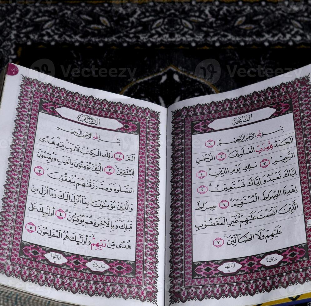 Al-Quran which is above the prayer rug with a black background photo