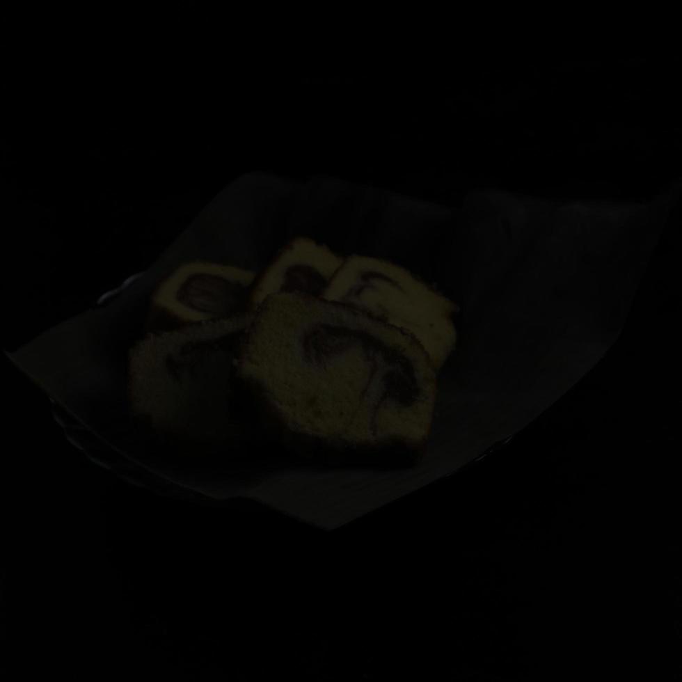 cake in a banana leaf container on a black background photo