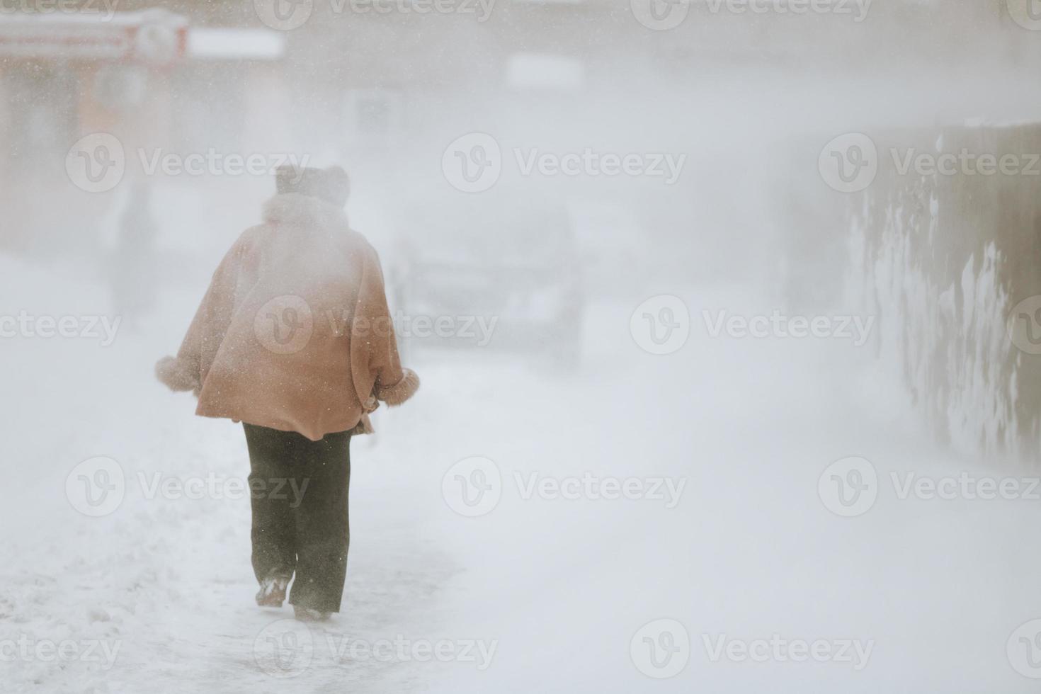 a man walks on the street during a blizzard and snowfall. photo