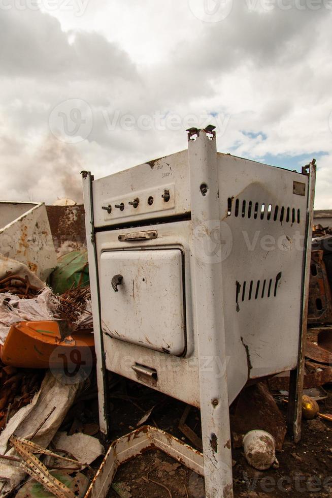 rusty old gas stove on scrap metal in the open air. photo