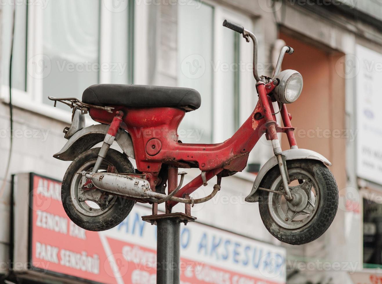 a retro moped is mounted on top of a rack for advertising. photo