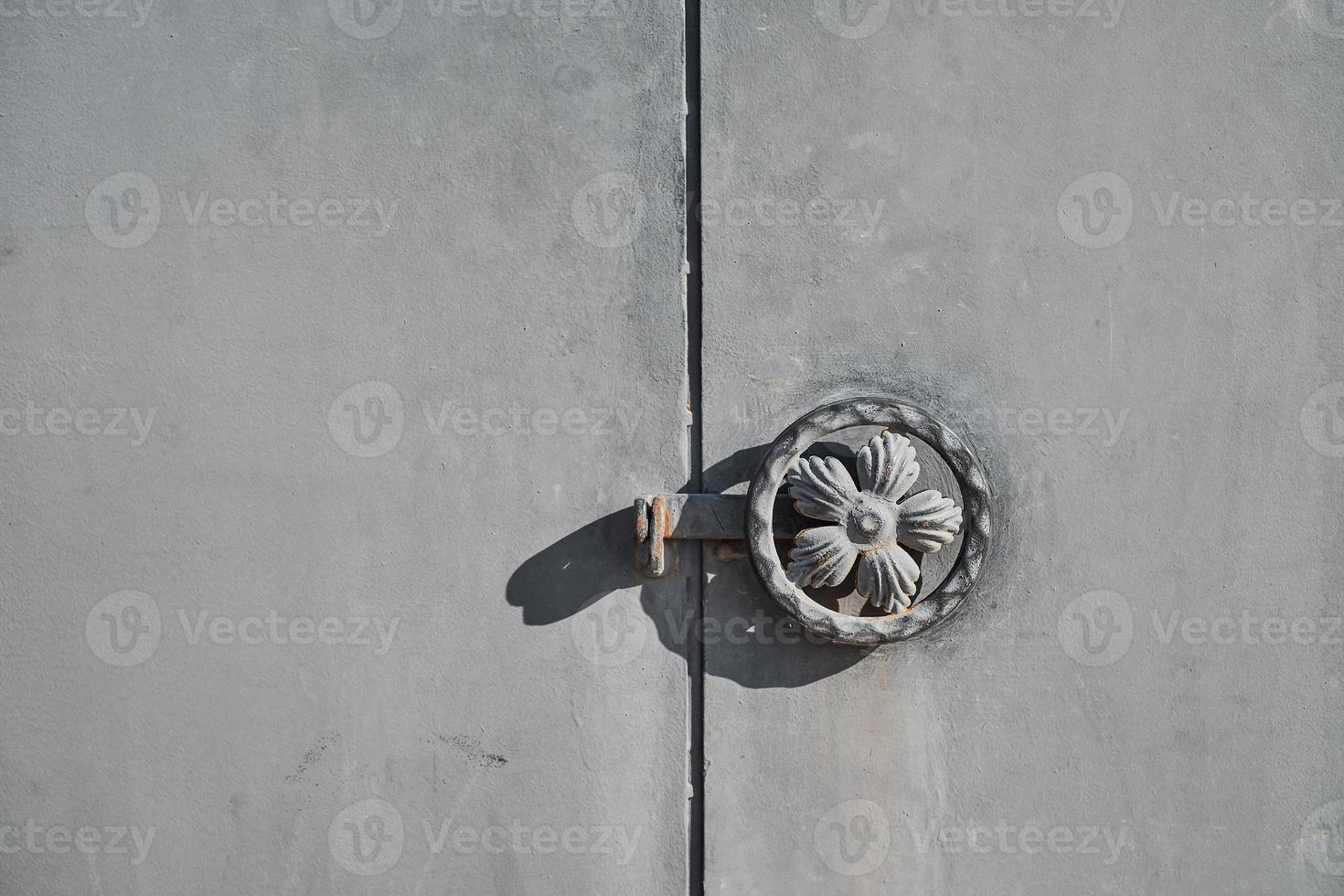 Close-up of metal security doors with a round handle and a latch for a lock, an idea for a background or advertising. Space for text photo