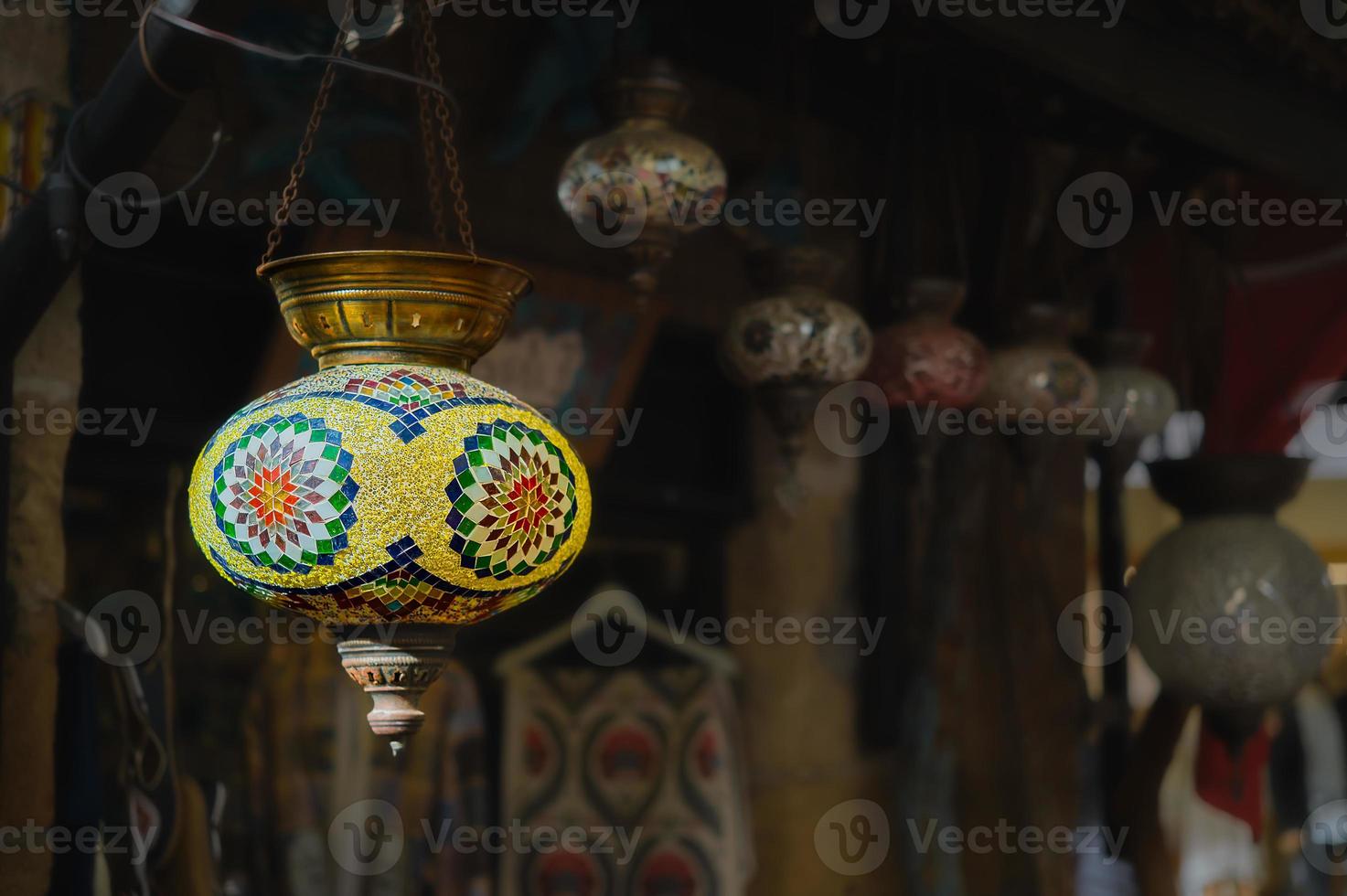 Turkey, a market with traditional colorful handmade Turkish lamps and lanterns, selective focus on a lantern, blurred background, lanterns hanging in a store for sale. Popular souvenirs photo