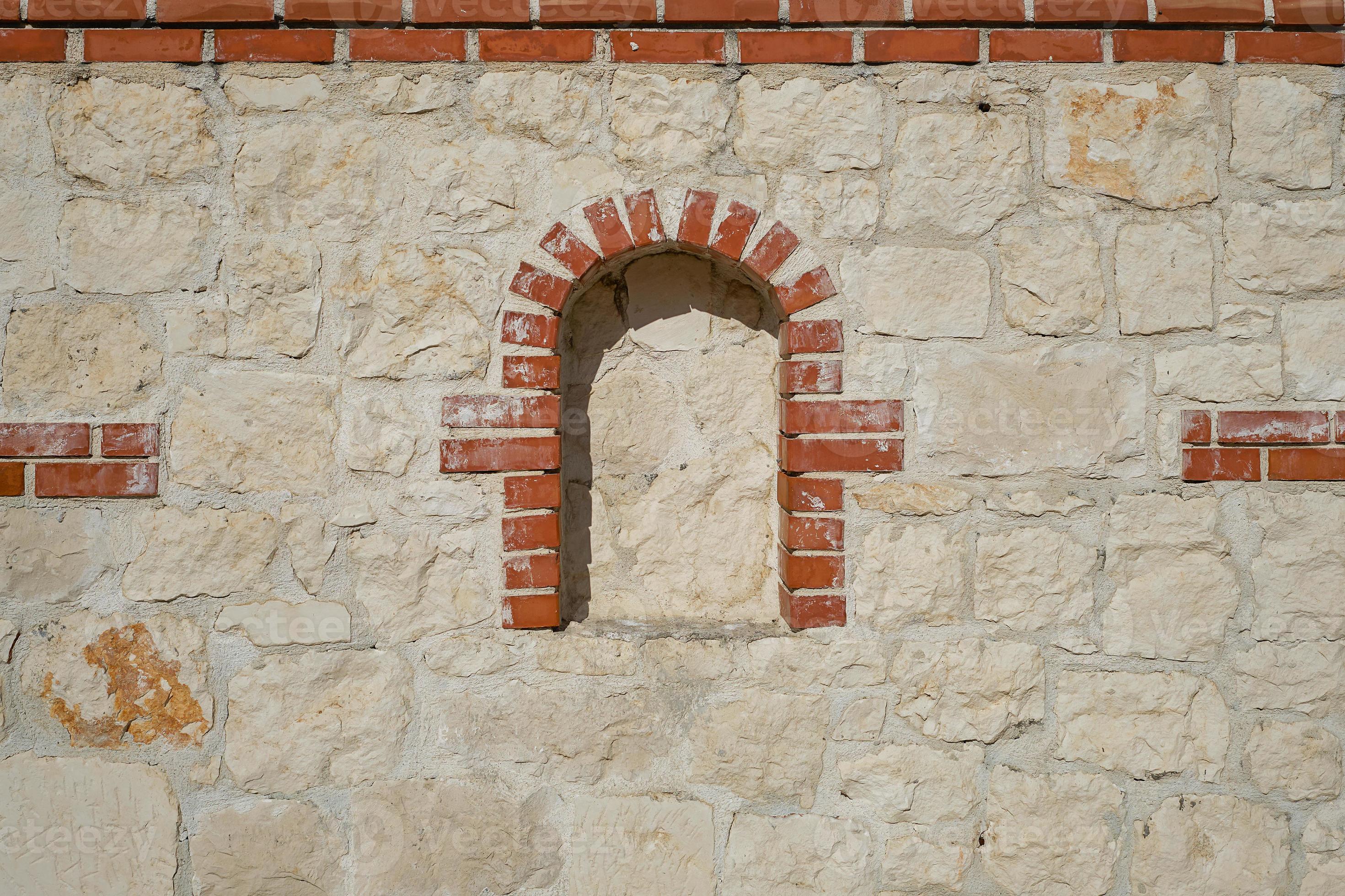 Wild limestone wall decorated with niche bricks, idea for background or
