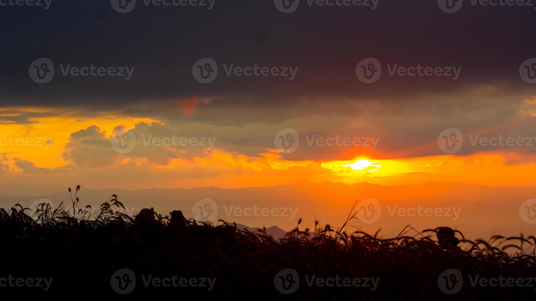 amanecer en el paisaje de colinas y prados. la gente sube a las montañas para ver el paisaje, el sol, el amanecer y el horizonte sobre el suelo foto