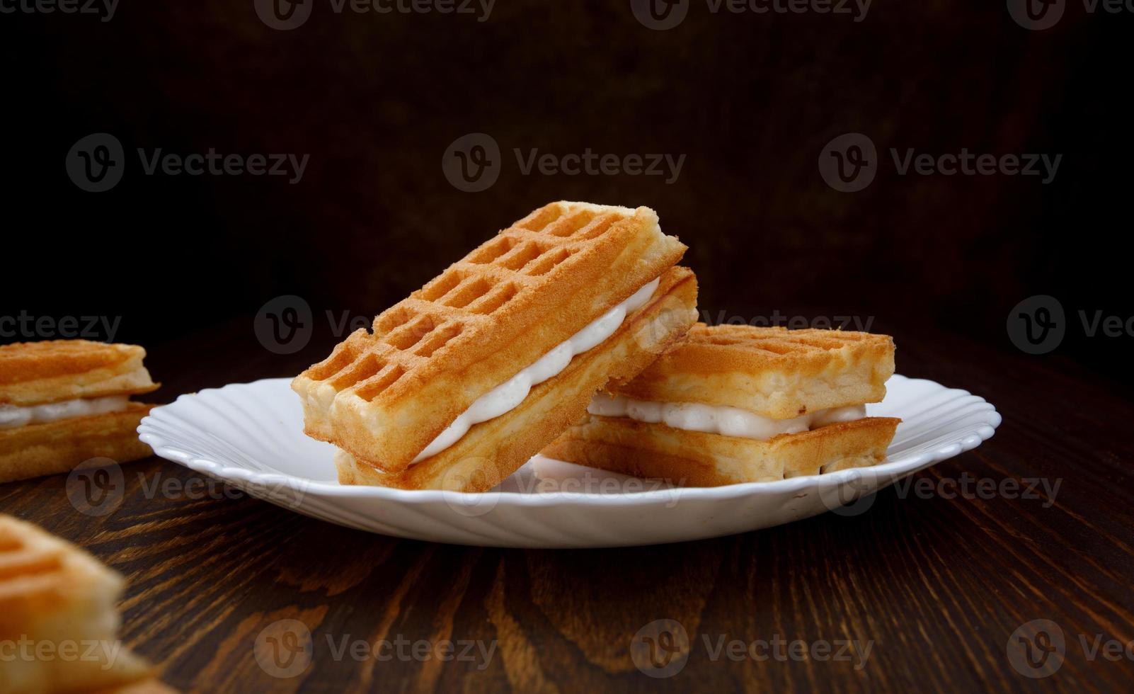 Viennese waffles lie on and next to a white plate. photo