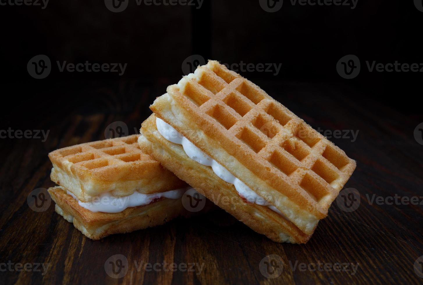 Viennese waffles with cream lie on a wooden table. photo