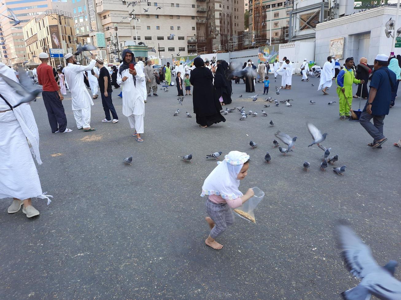 Mecca, Saudi Arabia, Dec 2022 - Pigeons in the outer courtyard of Masjid al-Haram, Mecca, Saudi Arabia eat grain offered by pilgrims. photo