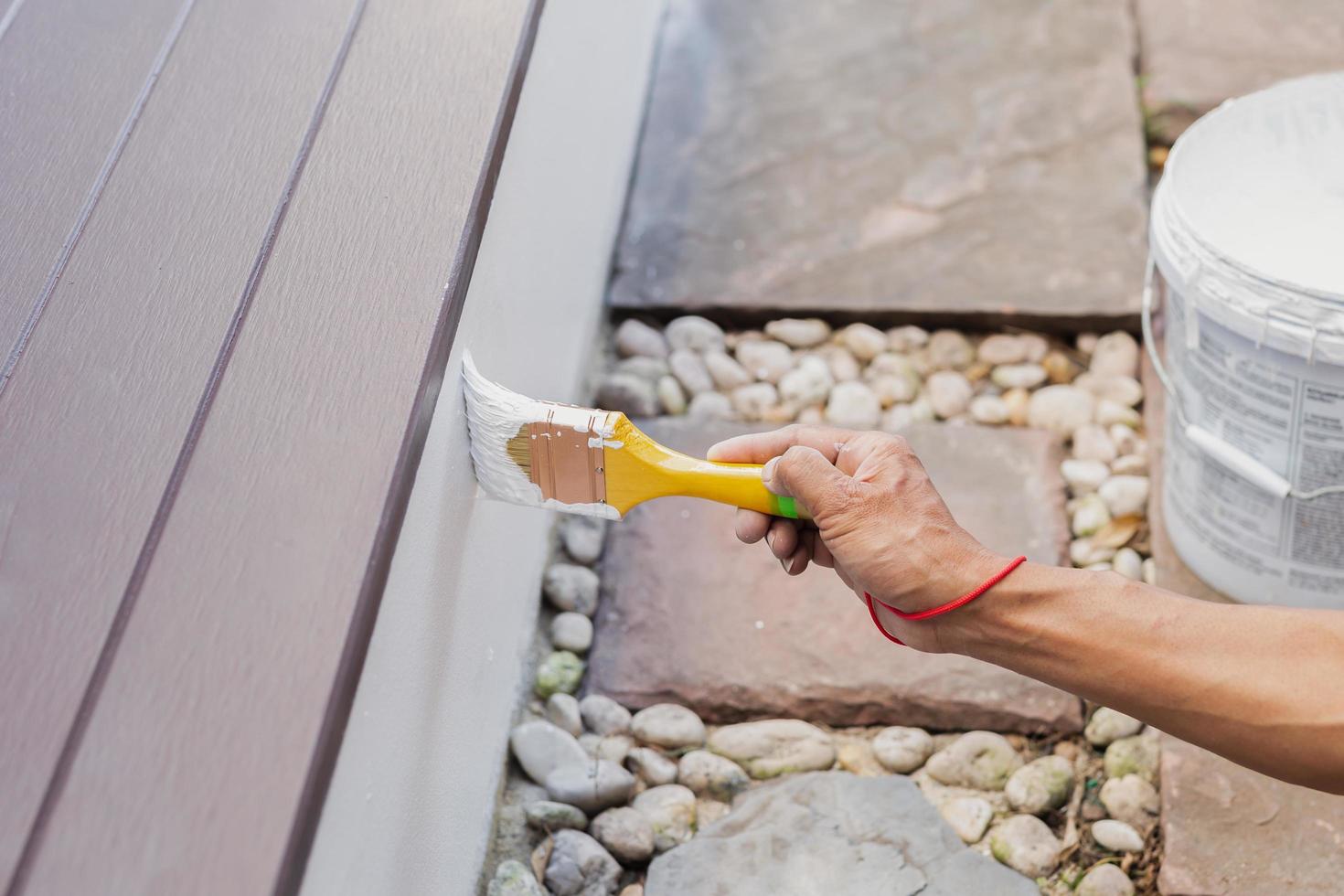 Hand painting outside wall with white color. photo