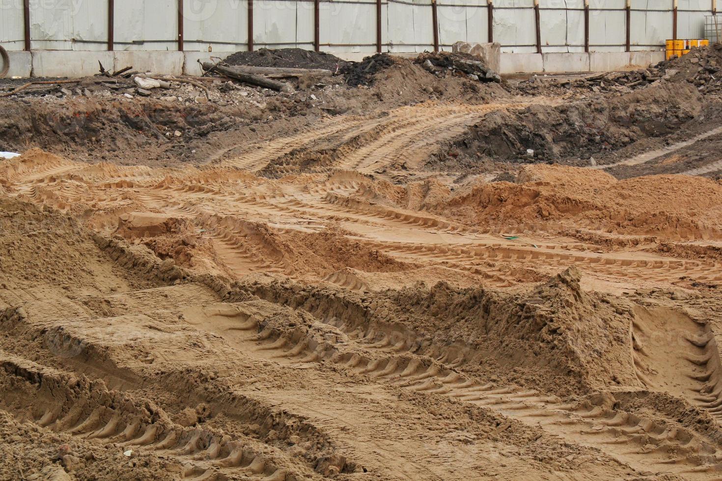 Tire track mark lines shape on dry sand background. Trail tyre imprint from heavy machinery. Vehicle shape. Road construction site backdrop concept. Trace of wheel pattern on mud. Nature texture. photo