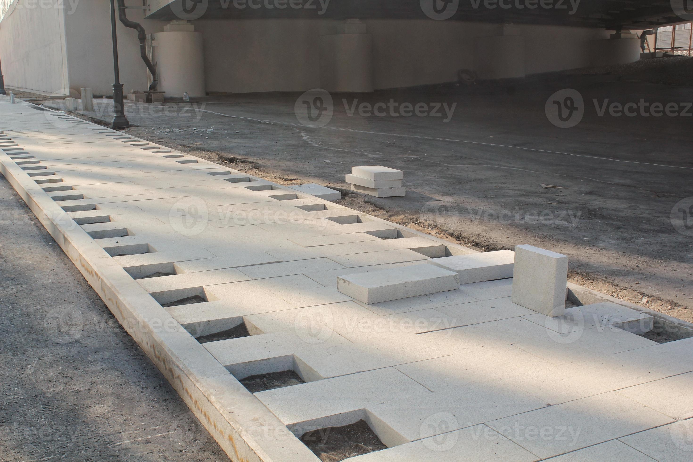Laying outdoor bricks concrete grey paving slabs on the street. Urban