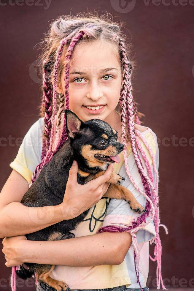 A teenage girl with a dog in her arms. The little girl had a pet chihuahua. photo