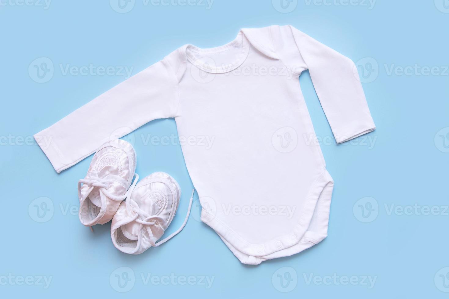 bodysuit and booties for a newborn on a blue background photo