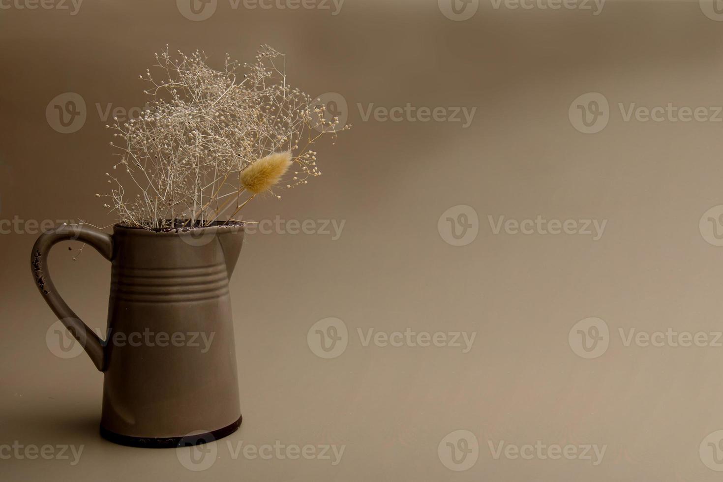 jarra de cerámica con flores secas sobre un fondo oscuro con espacio para copiar foto