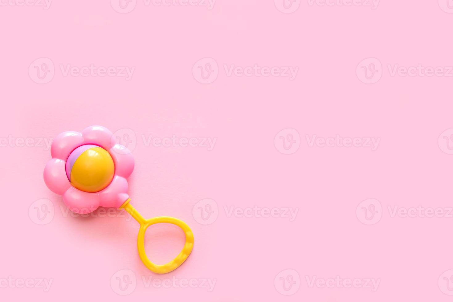 rattle on a pink background with copy space photo