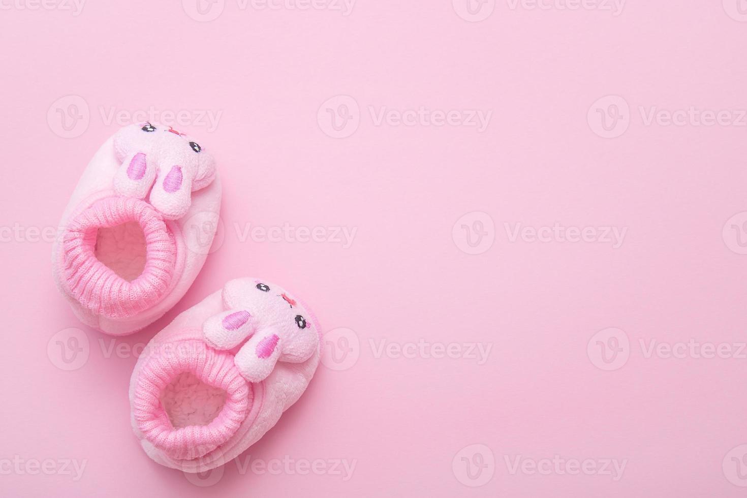 booties in the shape of a hare on a pink background with copy space photo