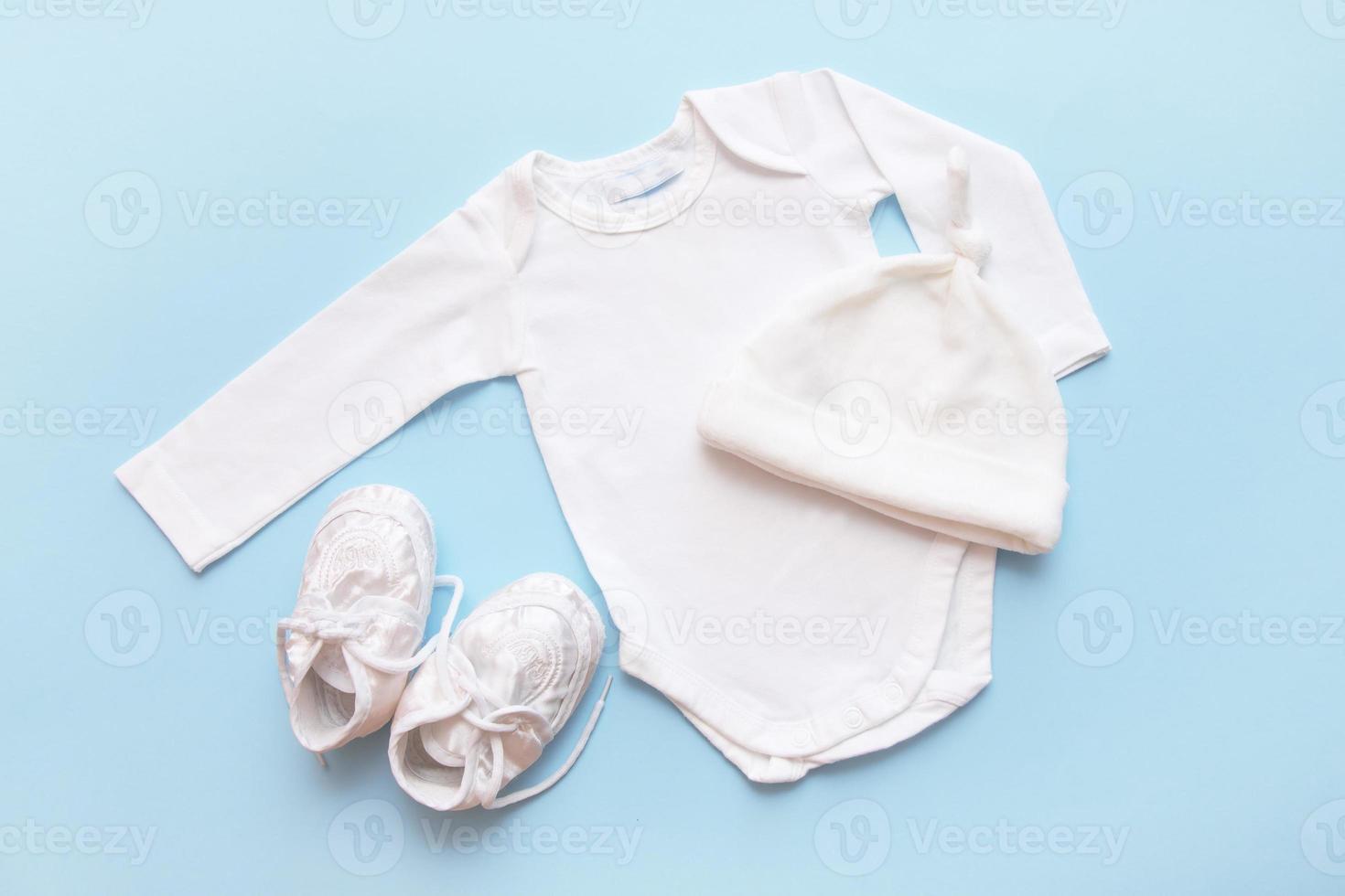 bodysuit for a newborn, cap and booties on a blue background photo