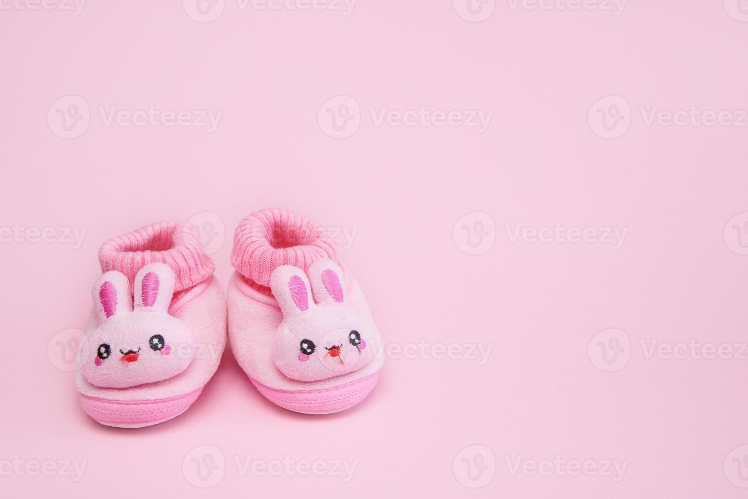 booties in the form of hares on a pink background with copy space photo