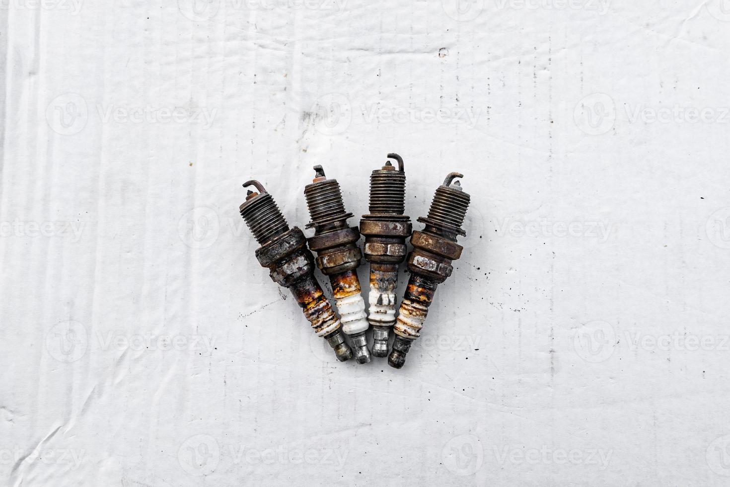 old used car spark plugs in rust on a white background photo