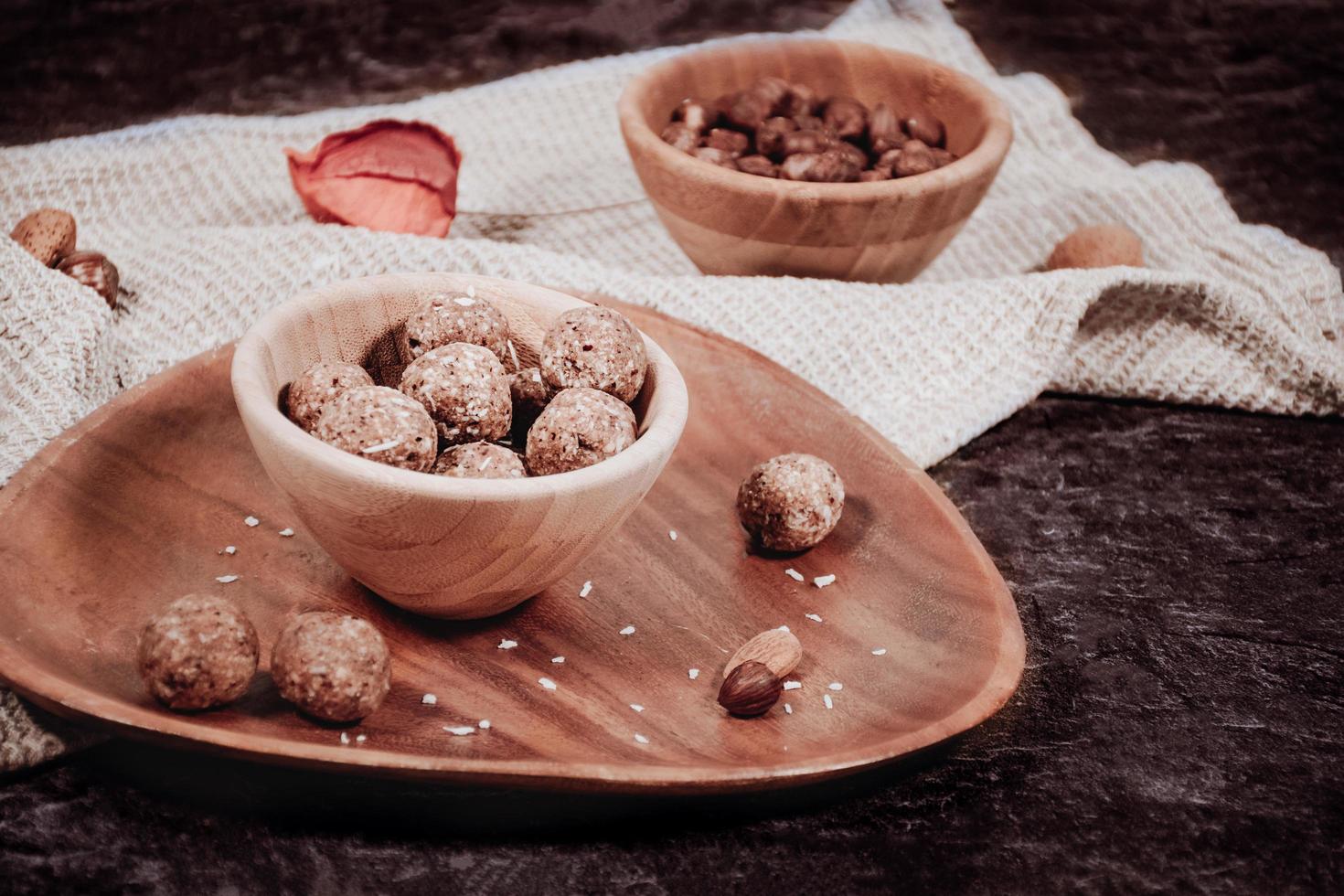 bolas dulces de energía cruda en a. plato de madera con nueces foto