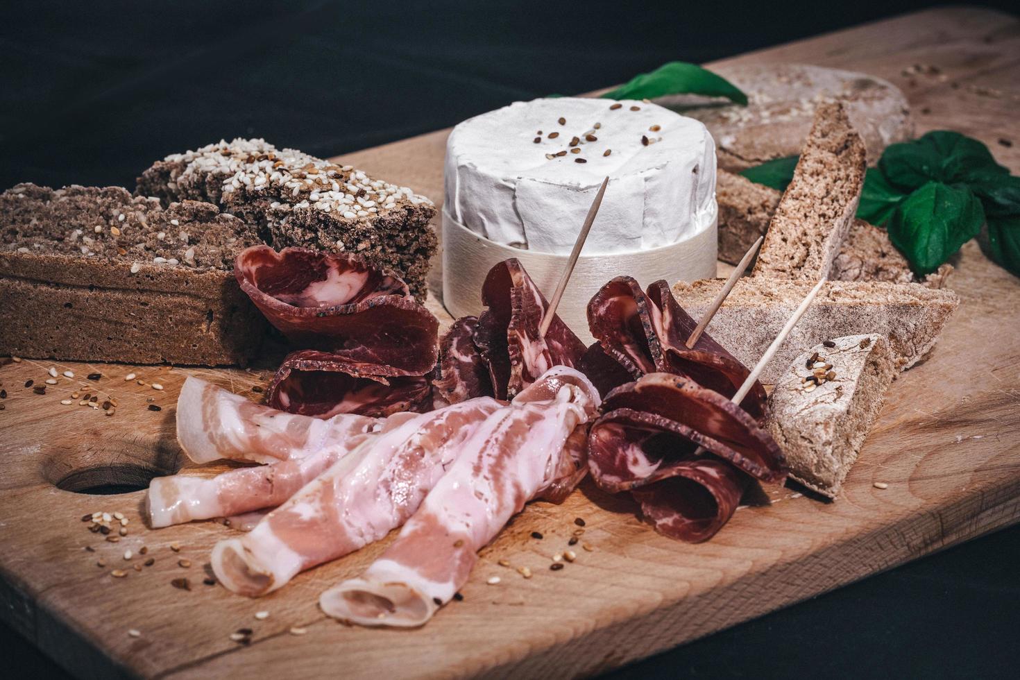 un plato de embutidos con pan integral casero y queso azul foto